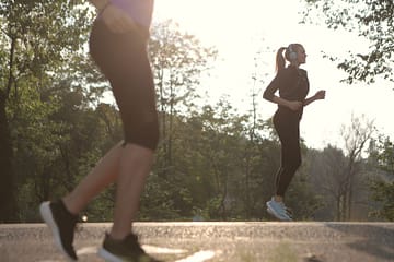 Δύο γυναίκες τρέχουν σε δροσερό πάρκο — τριπλέτα αδυνατίσματος και μεταβολισμός